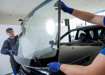 Technician replacing a vehicle windshield