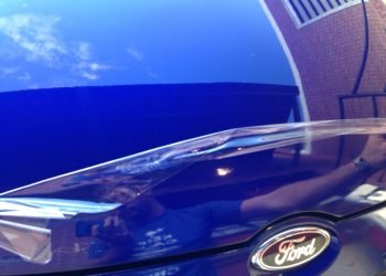 Clear paint-protection film applied to a blue vehicle's front end